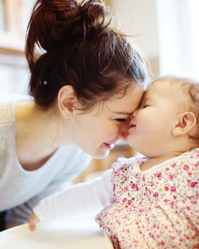 Young mother and her little daughter having breakfast together